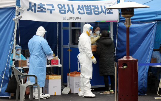 29일 오전 서울 서초구 고속터미널역 앞에 마련된 코로나19 임시 선별검사소에서 의료진이 검사를 하고 있다. 연합뉴스